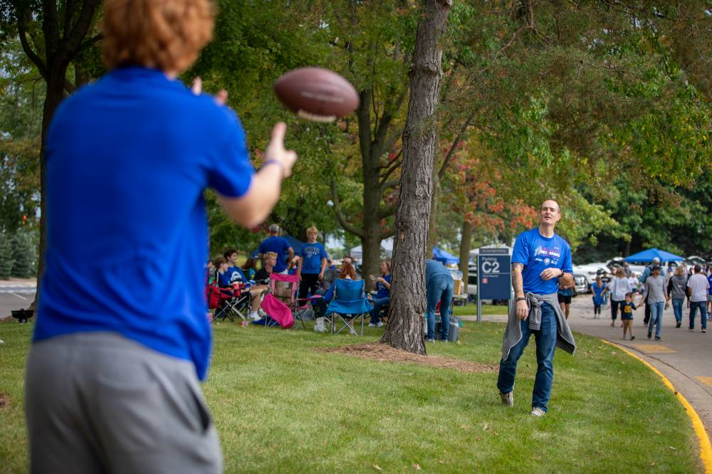 Attendees throw football during tailgate.